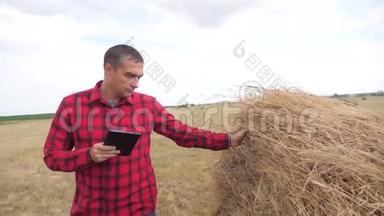 智慧<strong>农业</strong>理念.. 在<strong>数字</strong>平板电脑上研究干草堆的农民。 慢动作